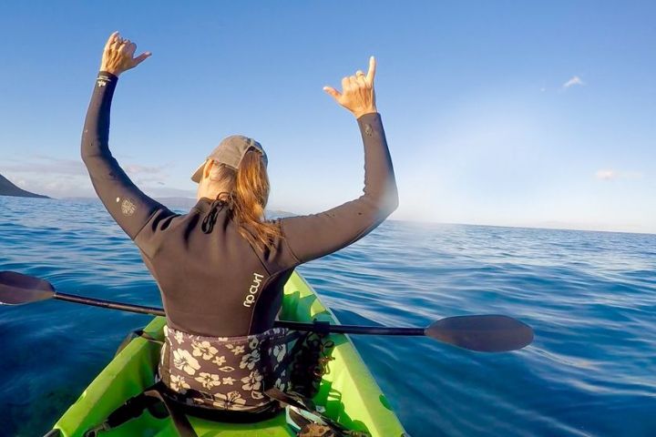 a woman standing next to a body of water