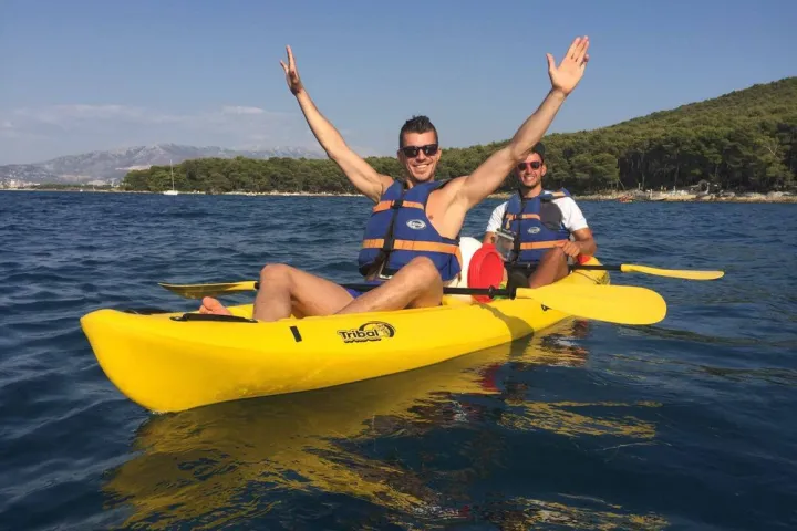 a man riding on the back of a boat in a body of water