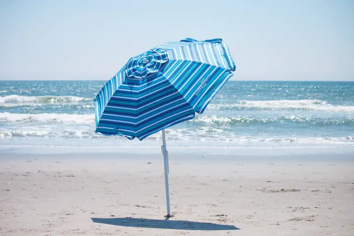 an umbrella sitting on top of a sandy beach