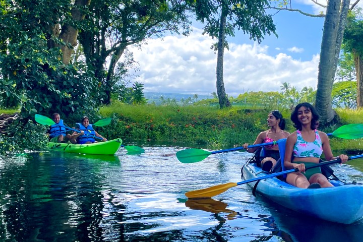 a group of people riding on the back of a boat in the water