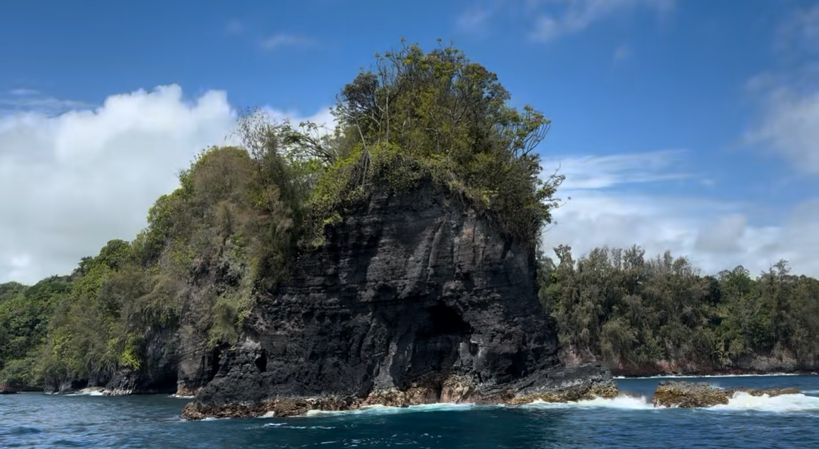 Shark Fin Rock rising from the water in Onomea Bay