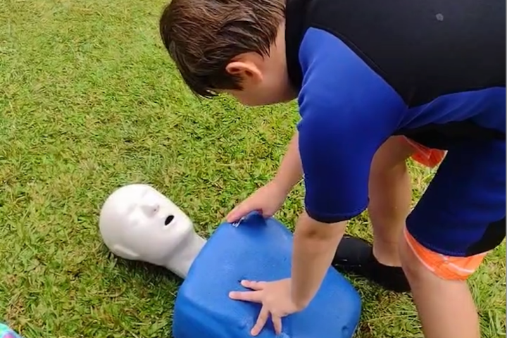 a little boy that is sitting in the grass