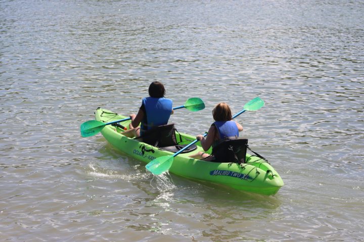 a group of people riding on the back of a boat in the water