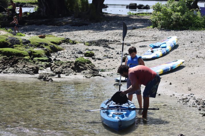 a man riding on the back of a boat in the water