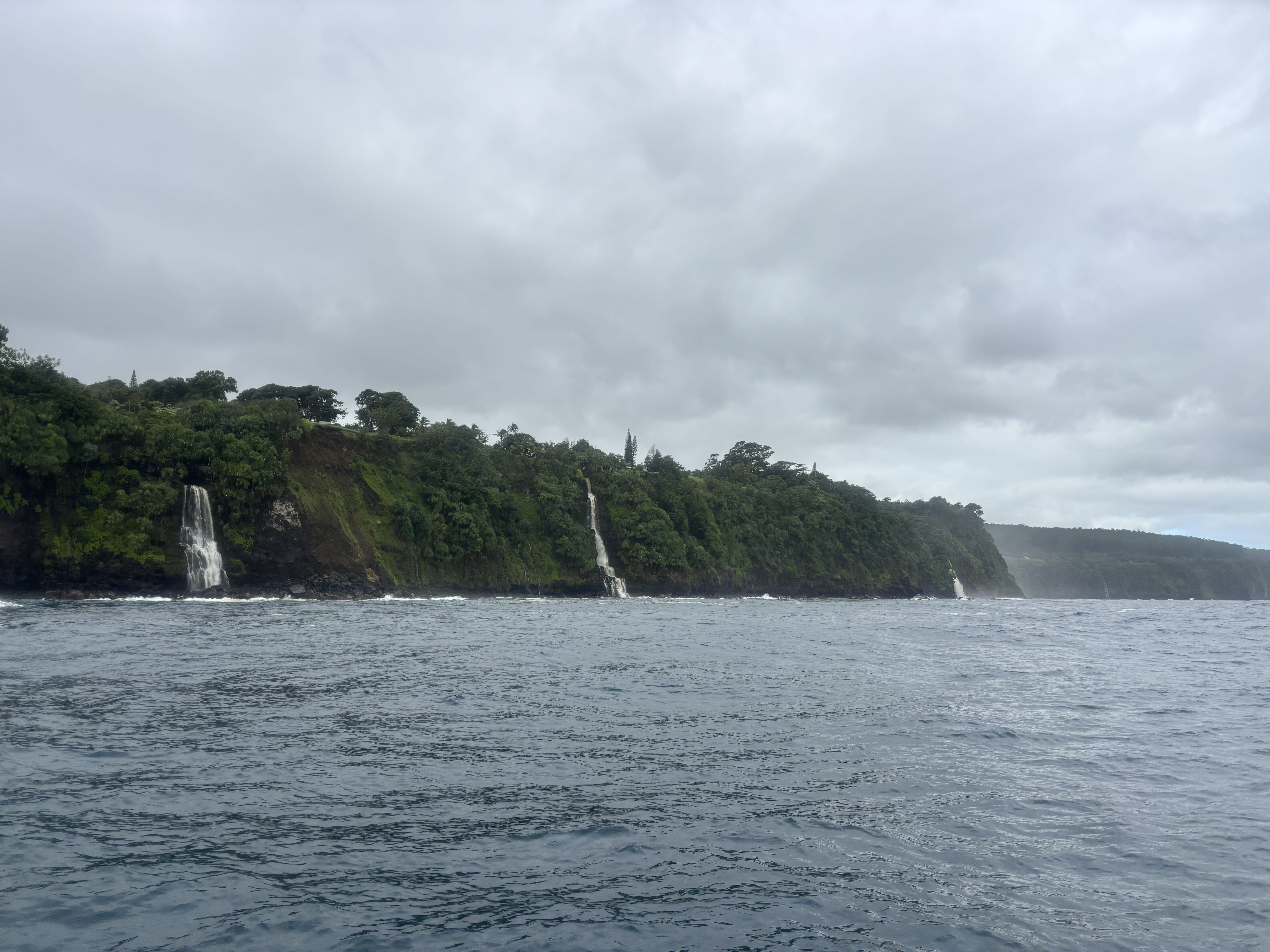 Waterfalls dropping off remote sea cliffs on the Hāmākua Coast